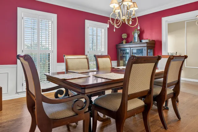 a view of a dining room with furniture a chandelier and wooden floor