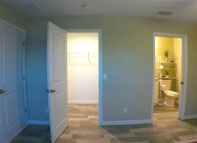 a bathroom with a granite countertop sink toilet and mirror