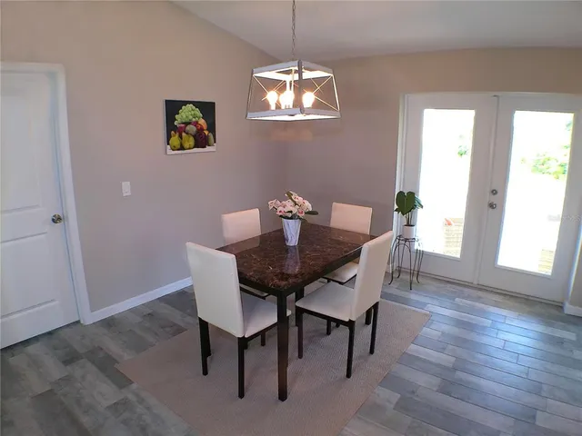 a view of a dining room with furniture a chandelier and wooden floor