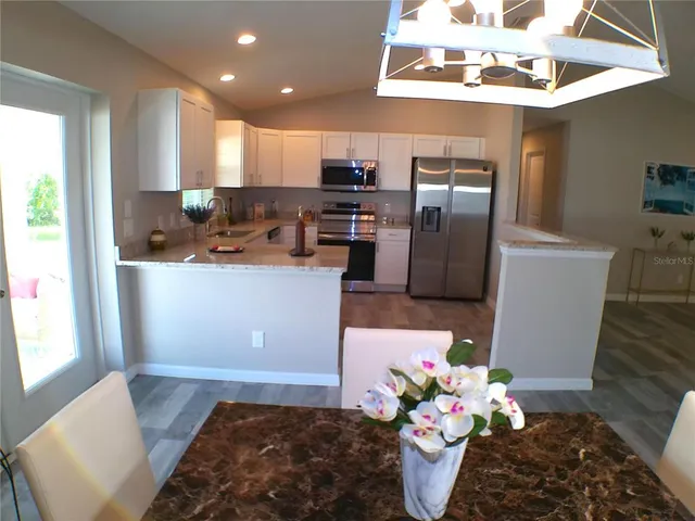 a kitchen with stainless steel appliances granite countertop a refrigerator a stove a sink and dishwasher