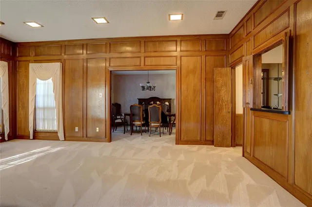 a view of an empty room with wooden floor and a bathroom
