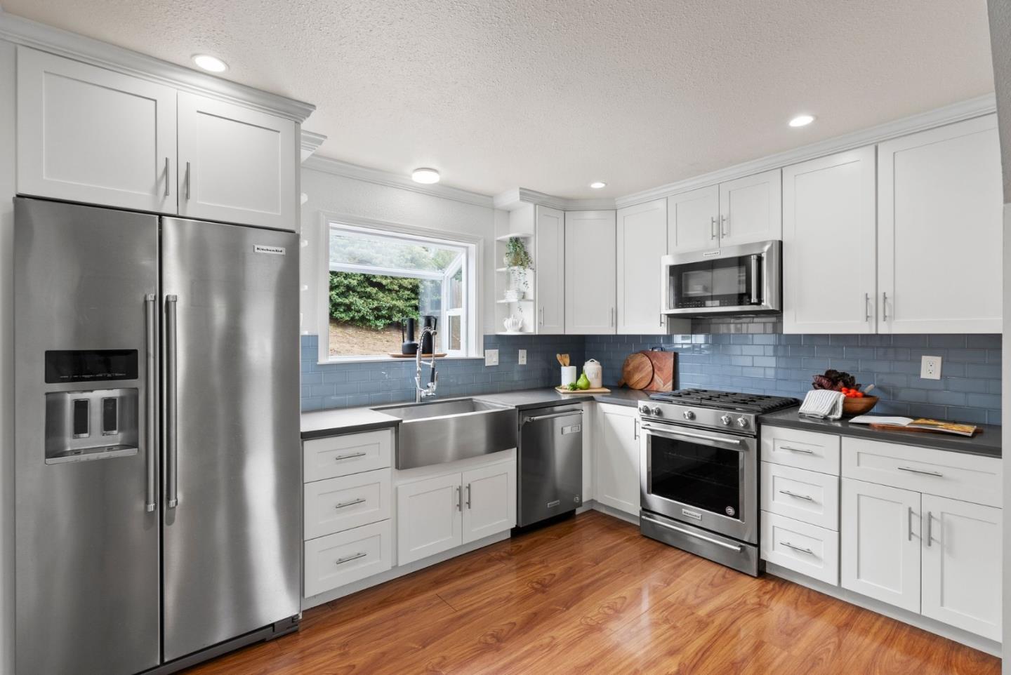 589 Inverness Drive Pacifica, CA 94044 - Photo 5 of 21 a kitchen with white cabinets stainless steel appliances and a refrigerator