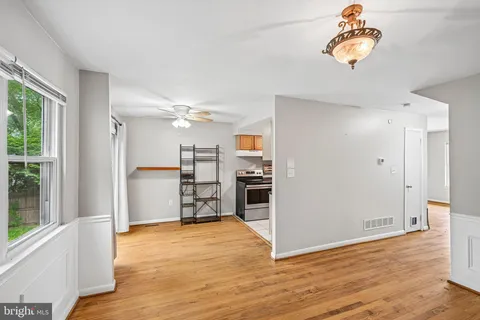 a view of a kitchen with refrigerator and wooden floor
