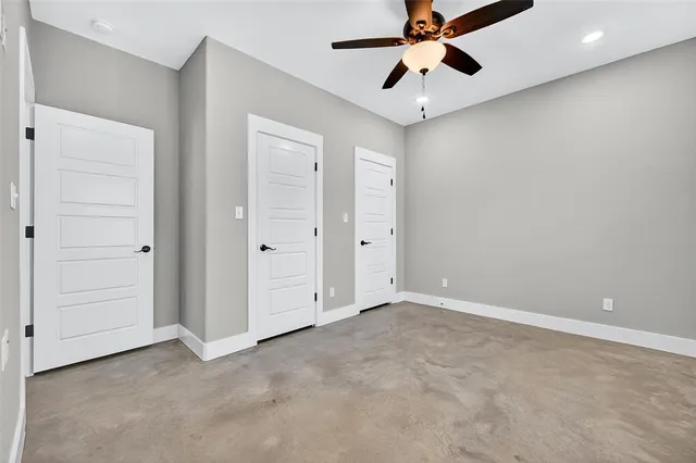an empty room with chandelier fan