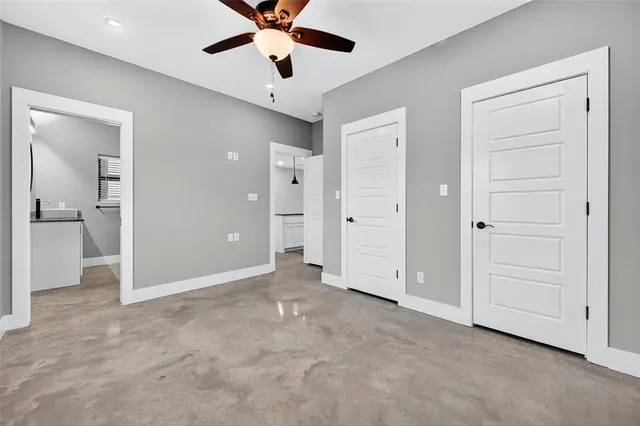 an empty room with fan and entrance