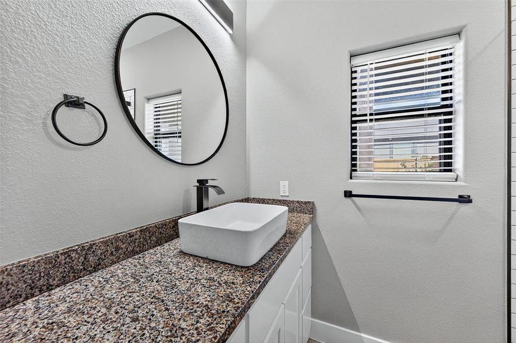 1431 South 7th Avenue Denison, TX 75021 - Photo 14 of 21 a bathroom with a granite countertop sink and a mirror