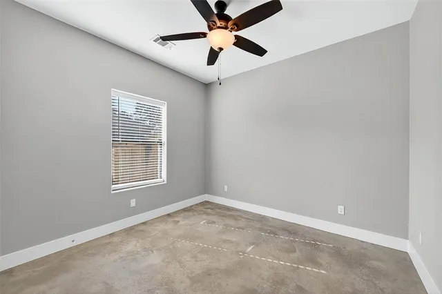 an empty room with a window and a fan