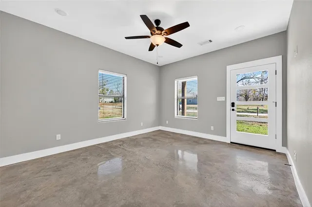 an empty room with window and ceiling fan
