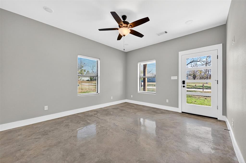 1431 South 7th Avenue Denison, TX 75021 - Photo 4 of 21 an empty room with window and ceiling fan