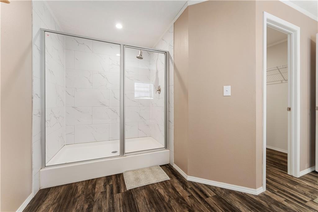 89 Ridge Road Seale, AL 36875 - Photo 25 of 46 Walk-in shower with clear glass enclosure, white tile surround, and built-in shower niche