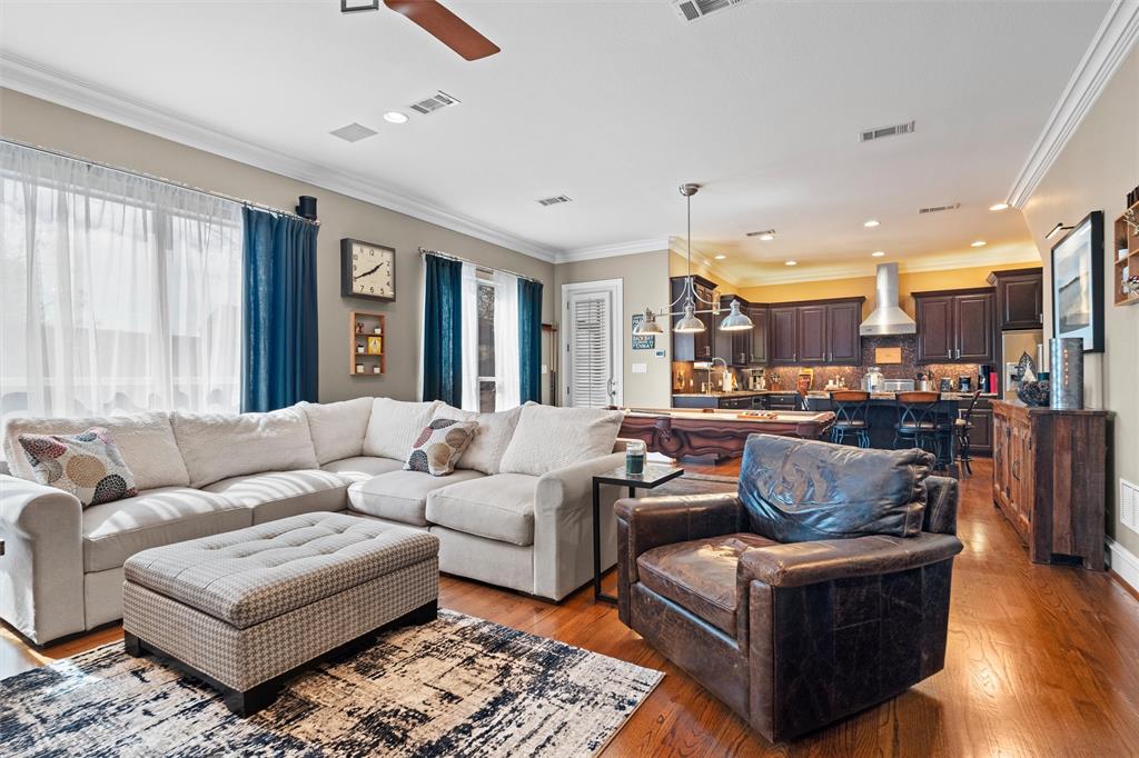 a living room with furniture wooden floor and a large window