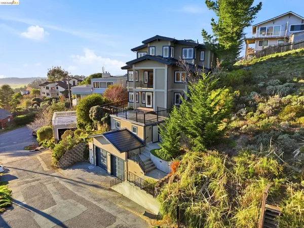 a front view of a house with a yard and parking spaces