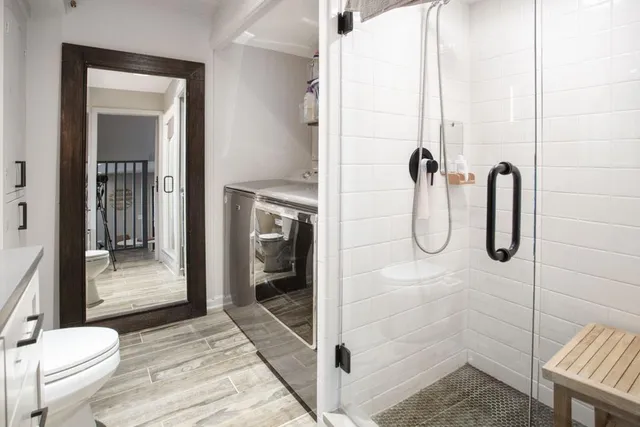a bathroom with a double vanity sink toilet and a mirror