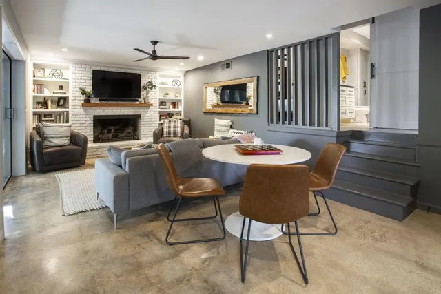 a living room with furniture a flat screen tv and a fireplace