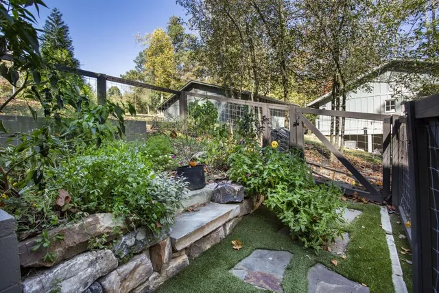 a view of a house with a large tree and wooden fence