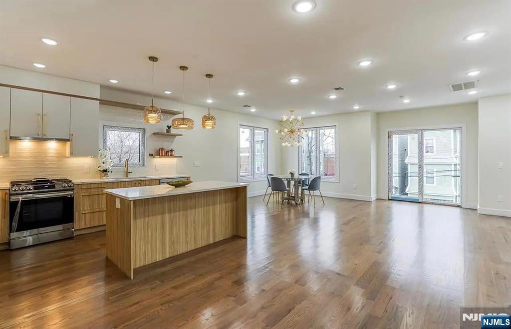 210 22nd Street, Unit 2 Irvington, NJ 07111 - Photo 6 of 20 a large kitchen with stainless steel appliances granite countertop a large counter top a stove and a wooden floors