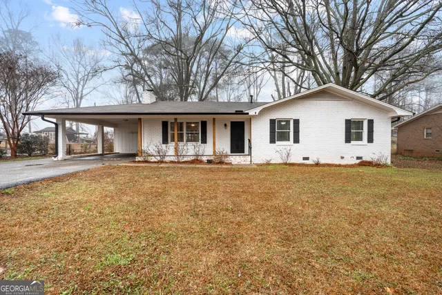 a front view of house with yard and trees around