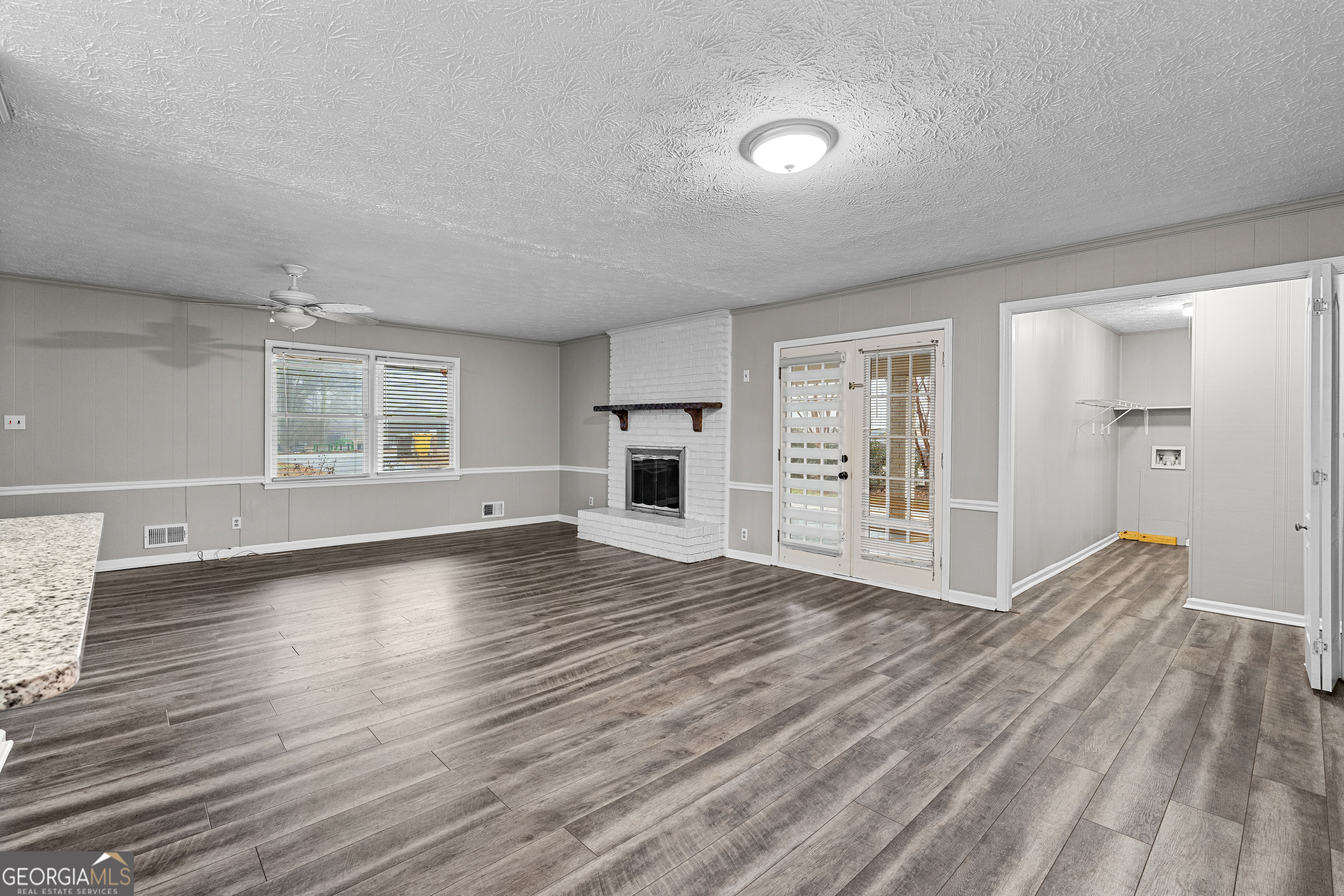 96 Poplar Road Newnan, GA 30263 - Photo 11 of 33 an empty room with wooden floor and windows