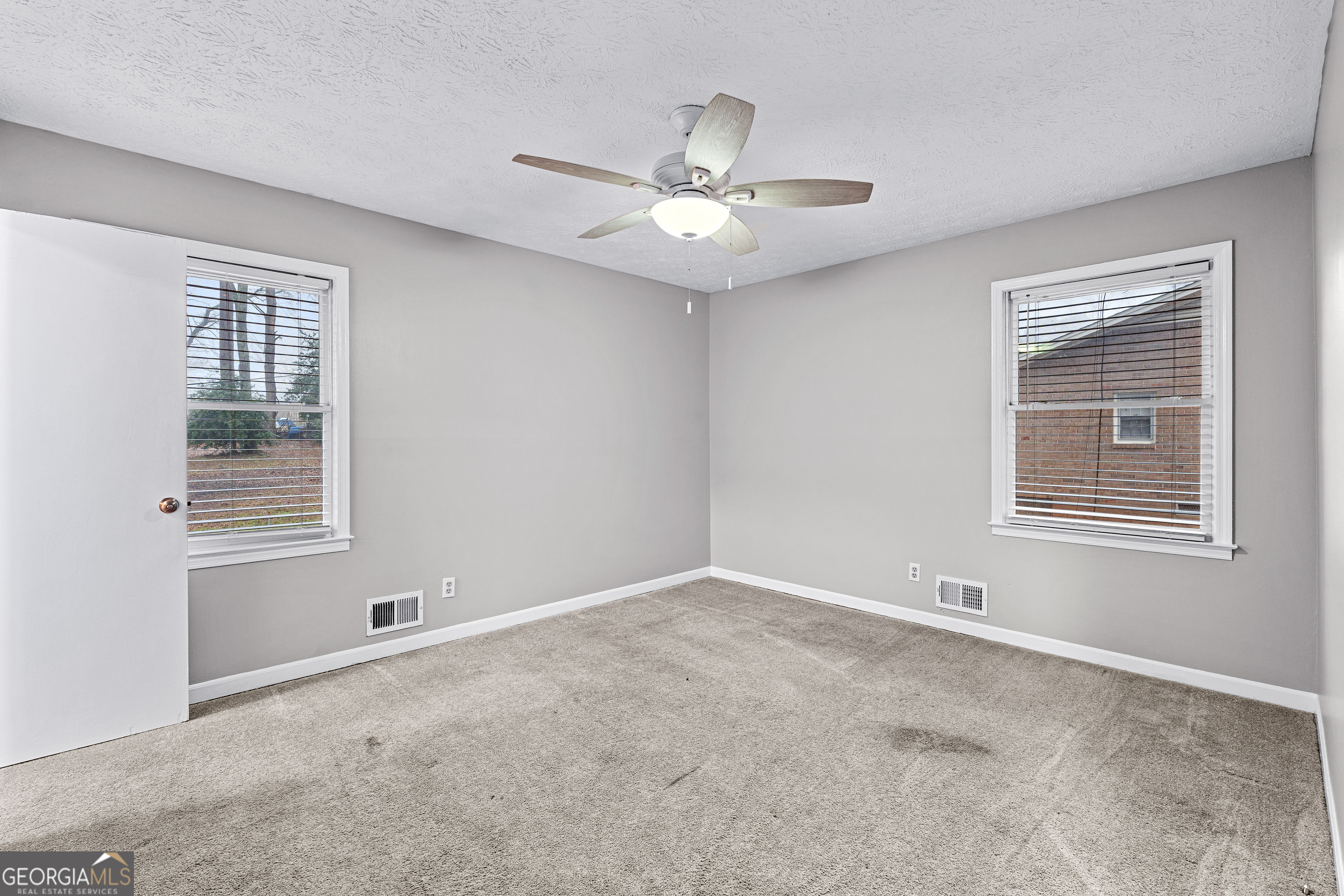 96 Poplar Road Newnan, GA 30263 - Photo 23 of 33 an empty room with a window and ceiling fan