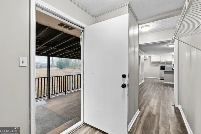 a view of a hallway with wooden floor and staircase
