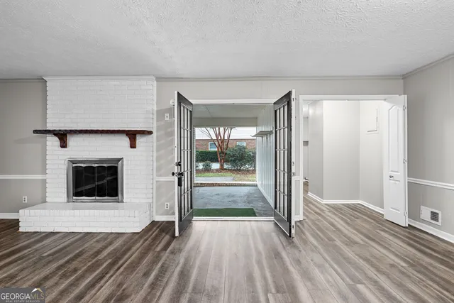 a view of a livingroom with wooden floor and a fireplace
