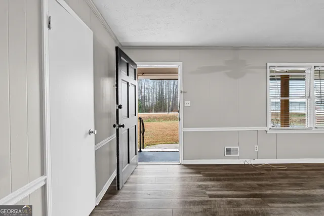 a view of a livingroom with wooden floor and a window