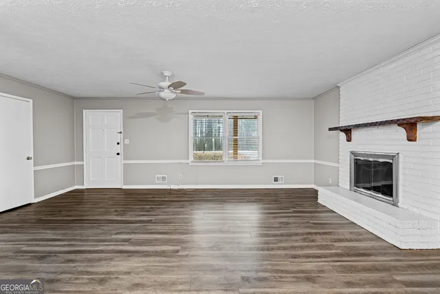 a view of an empty room with window and fire place