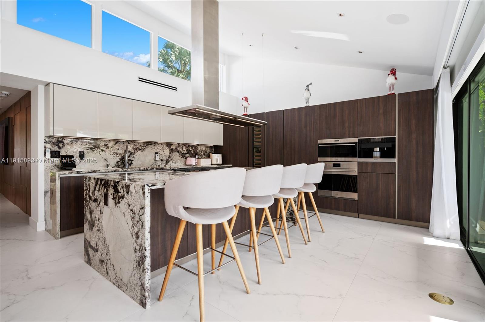 1792 Cleveland Road Miami Beach, FL 33141 - Photo 11 of 39 a kitchen with stainless steel appliances kitchen island granite countertop a table chairs microwave and sink