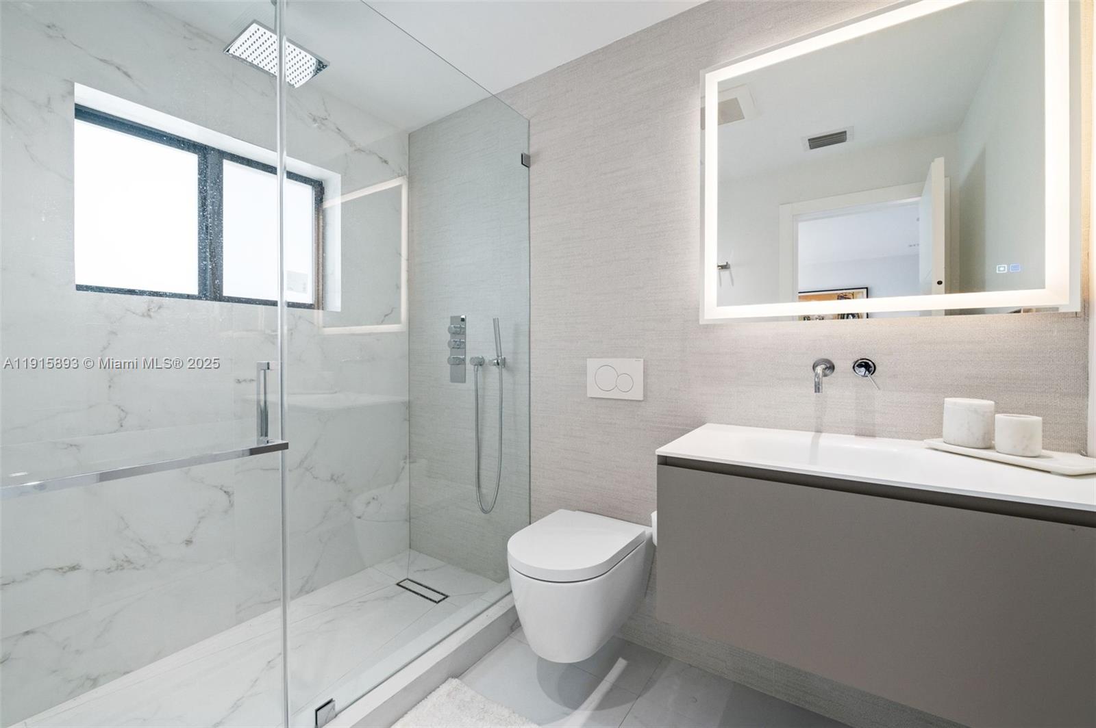 1792 Cleveland Road Miami Beach, FL 33141 - Photo 24 of 39 a bathroom with a toilet a sink a mirror and a shower