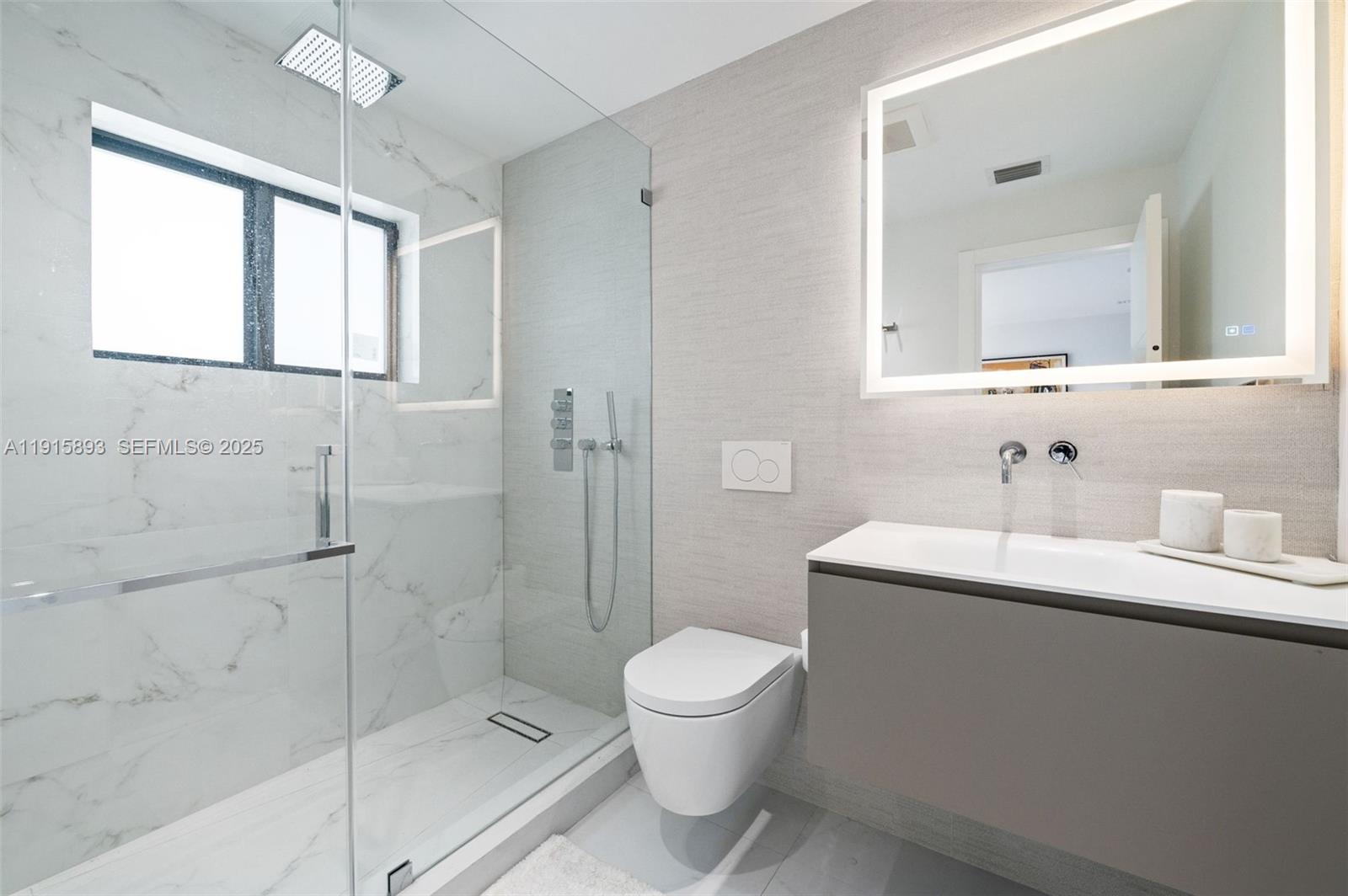 1792 Cleveland Road Miami Beach, FL 33141 - Photo 24 of 39 a bathroom with a toilet a sink a mirror and a shower