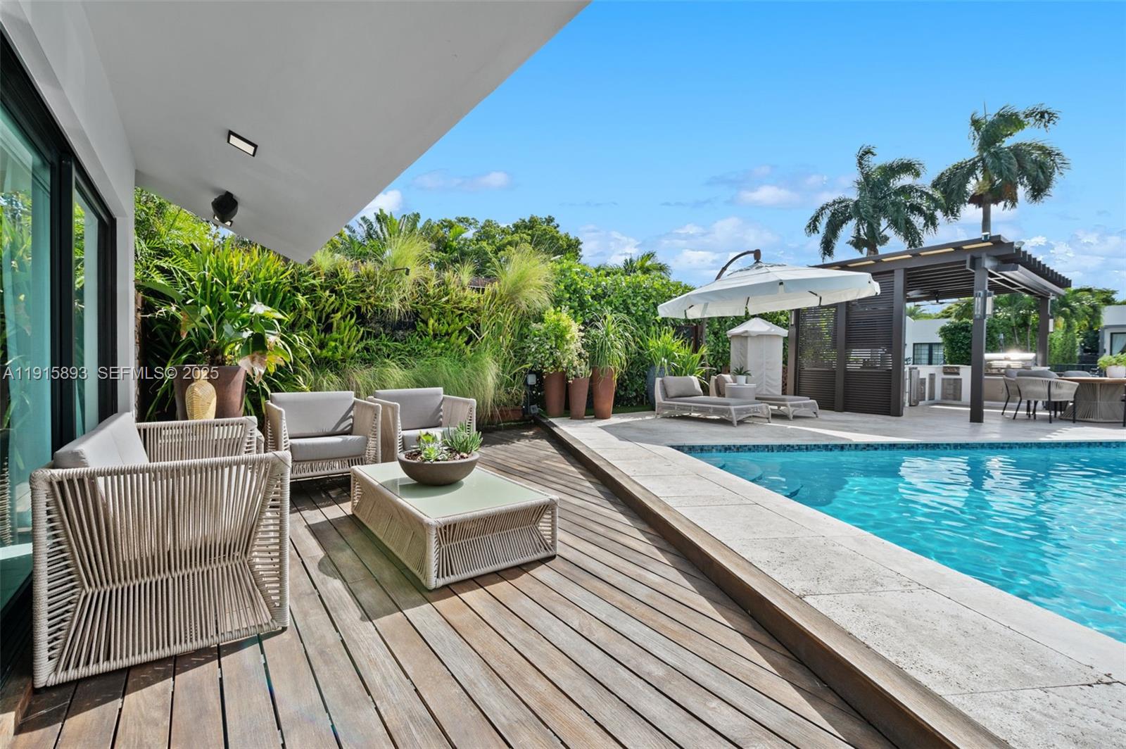 1792 Cleveland Road Miami Beach, FL 33141 - Photo 26 of 39 a view of a patio with couches table and chairs under an umbrella with wooden floor