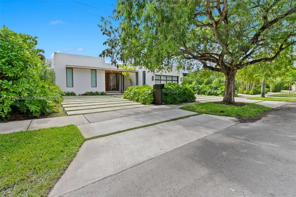 a view of a house with a yard and large tree
