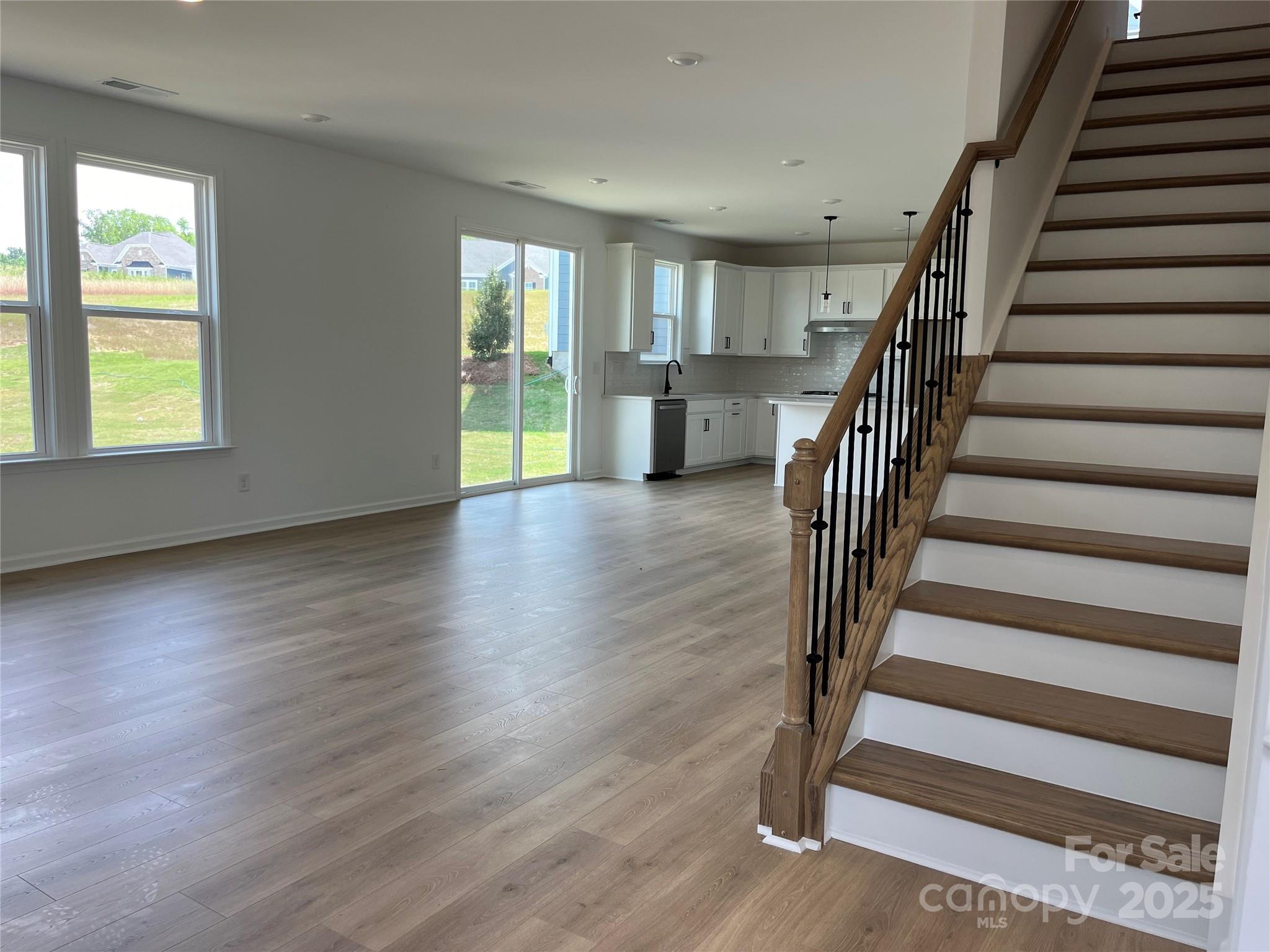 1476 Hubert Graham Way Tega Cay, SC 29708 - Photo 5 of 31 an empty room with wooden floor and windows