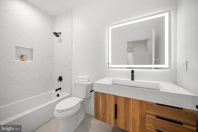 a bathroom with a bathtub sink and mirror