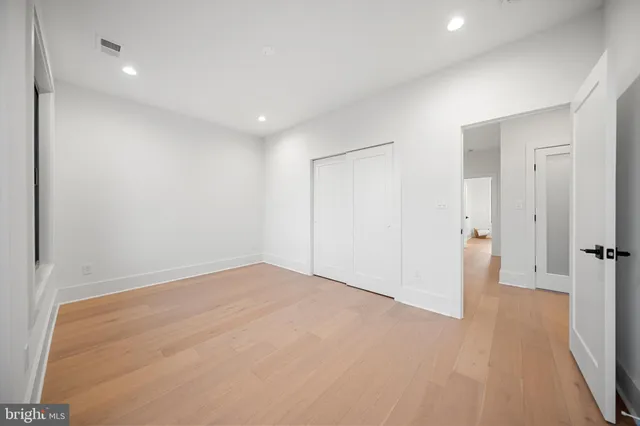 an empty room with windows and closet