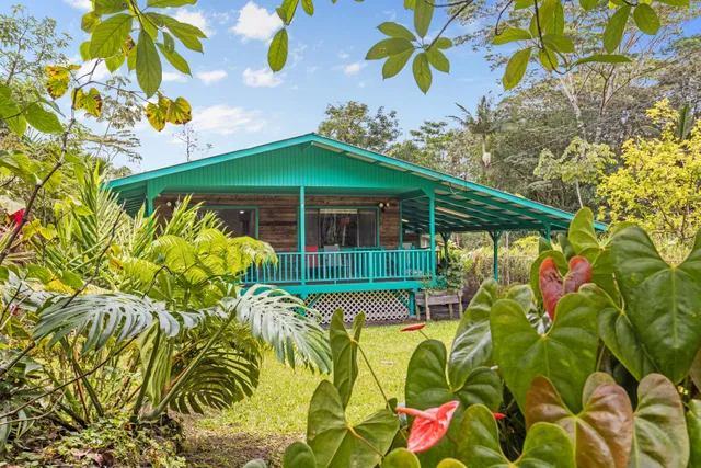 a view of a white house with a yard and sitting area
