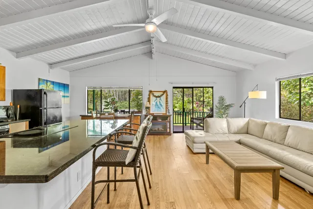 a living room with furniture a flat screen tv and a large window