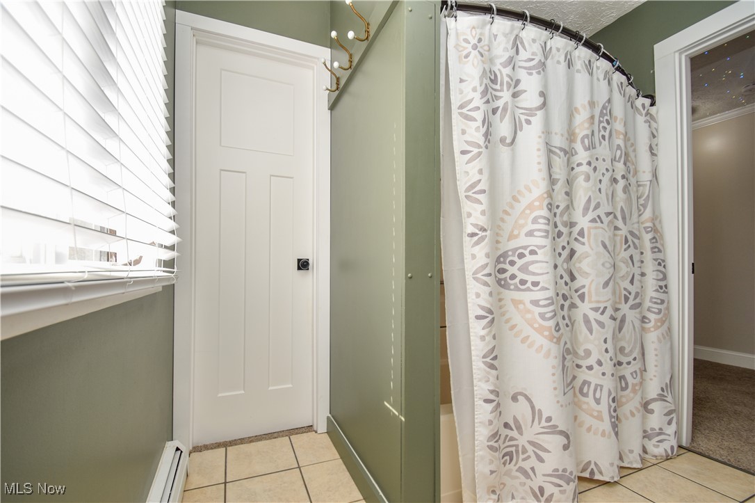 631 Carson Salt Springs Road Warren, OH 44481 - Photo 17 of 39 Bathroom with walk in shower, a baseboard radiator, and tile patterned flooring