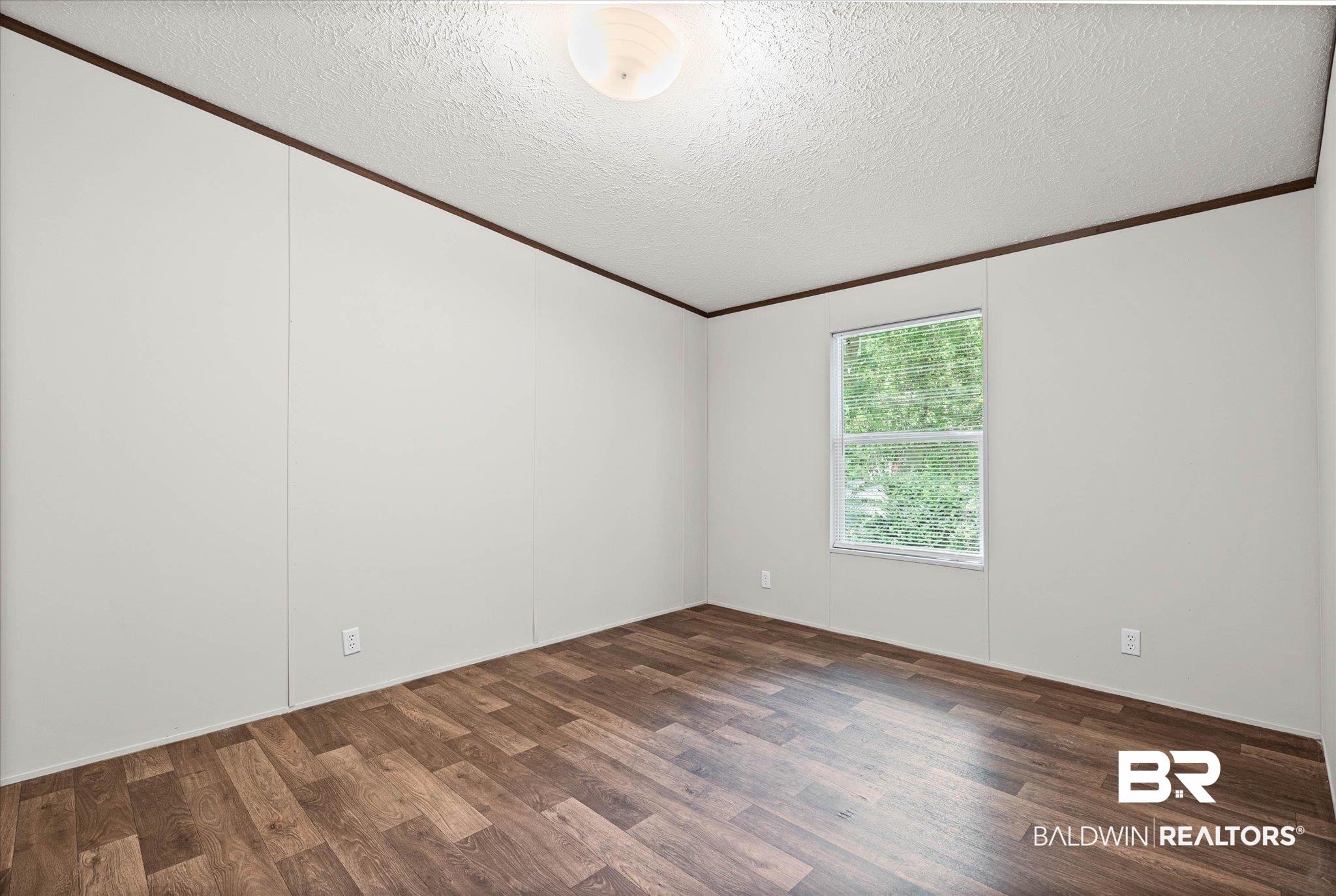 25366 Pollard Road Daphne, AL 36526 - Photo 15 of 22 Interior room featuring wood-finish flooring, white panel walls, and dark trim