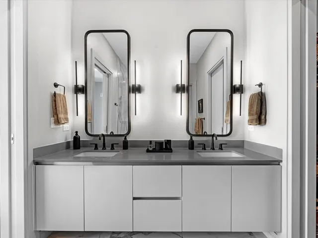 a bathroom with double sink and a mirror