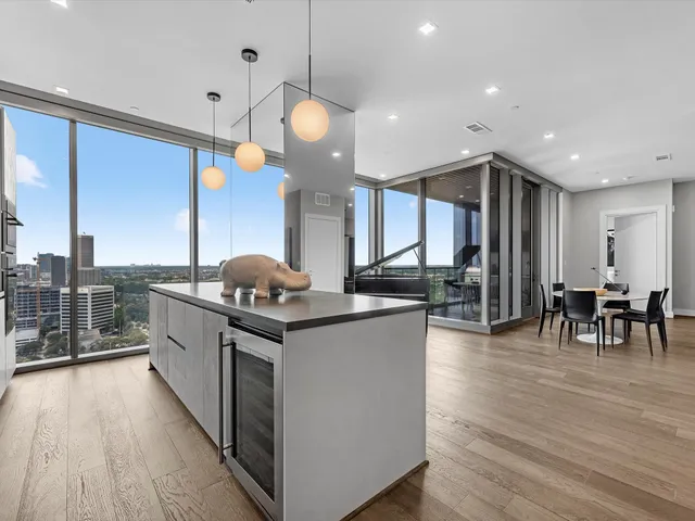 a kitchen with stainless steel appliances granite countertop a stove and chairs with wooden floors