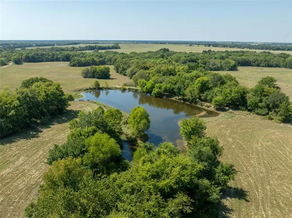 an aerial view of a house with a yard and lake view