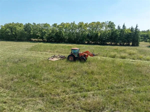 a view of a field with some trees in the background
