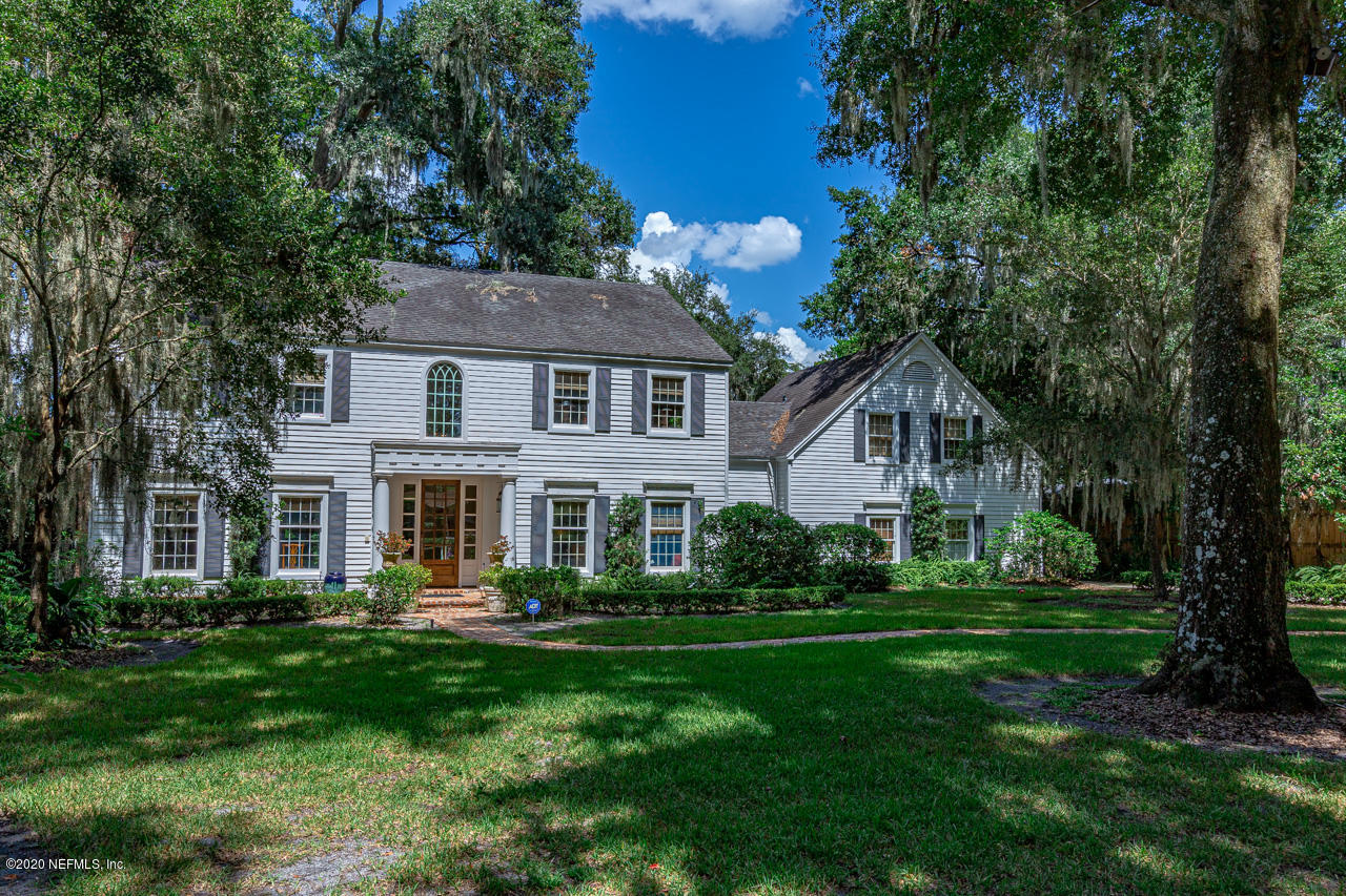 a front view of a house with a yard and trees