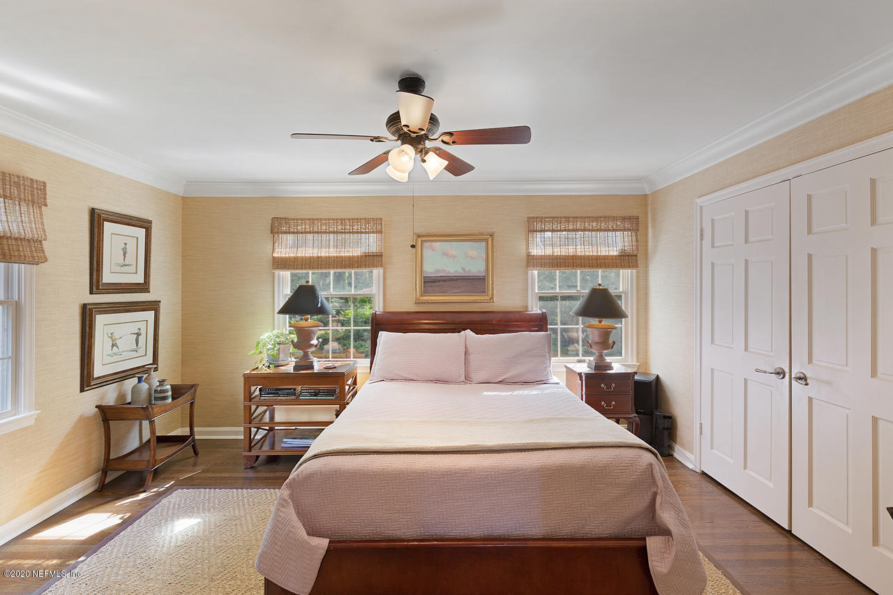 5015 River Point Road Jacksonville, FL 32207 - Photo 19 of 49 a bedroom with a large bed and a chandelier