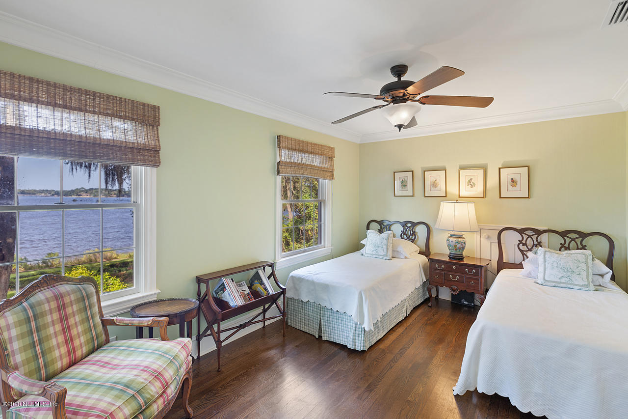 5015 River Point Road Jacksonville, FL 32207 - Photo 22 of 49 a bedroom with 2 bed and a chandelier