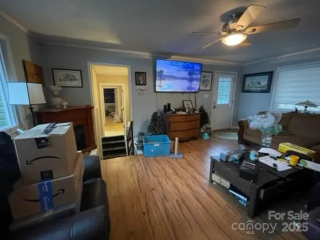 a living room with furniture and a flat screen tv with wooden floor