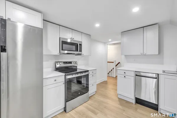 a kitchen with stainless steel appliances a stove microwave and refrigerator