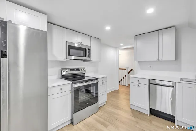 a kitchen with stainless steel appliances a stove microwave and refrigerator