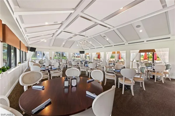 a dining room with furniture a chandelier and wooden floor